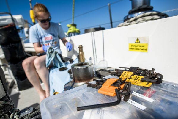 A woman making repairs to a yacht