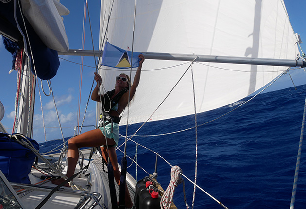 A woman raised a flag on a yacht at the end of crossing the Atlantic