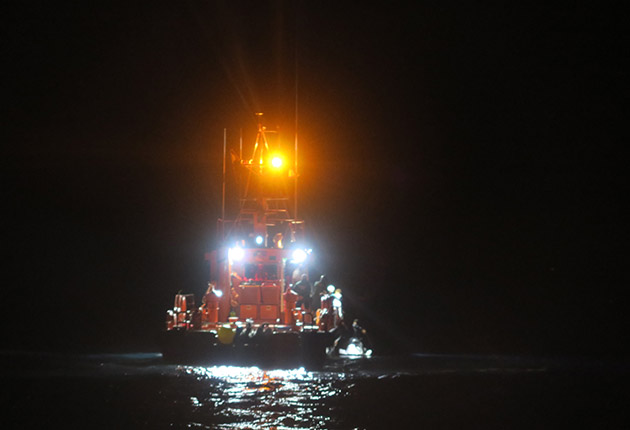 Migrants at sea being rescued by a lifeboat
