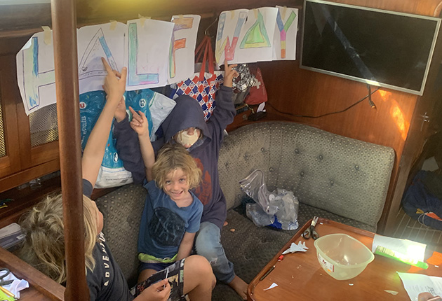 Two children with a half way sign to mark the half way point of an ocean crossing