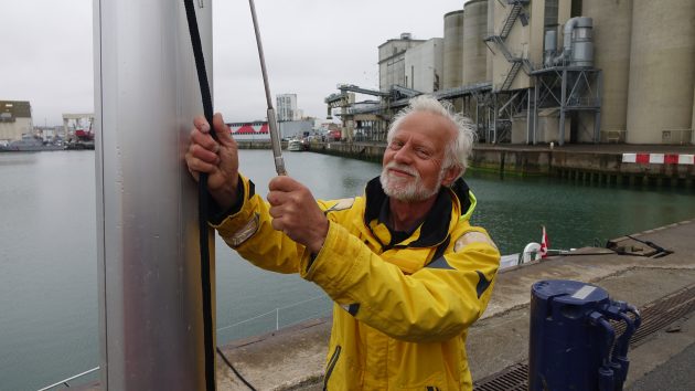Golden globe race skipper dward Walentynowicz holding onto a mast on his boat