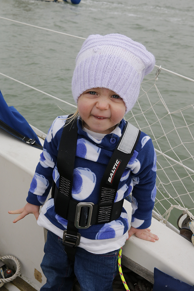 A child in a harness on a yacht
