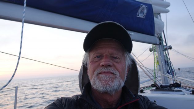 A man in a cap standing on a deck of a boat