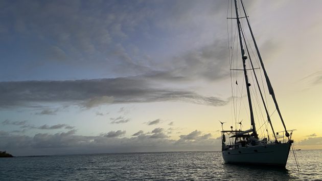 A yacht in silhouette anchored in the ocean