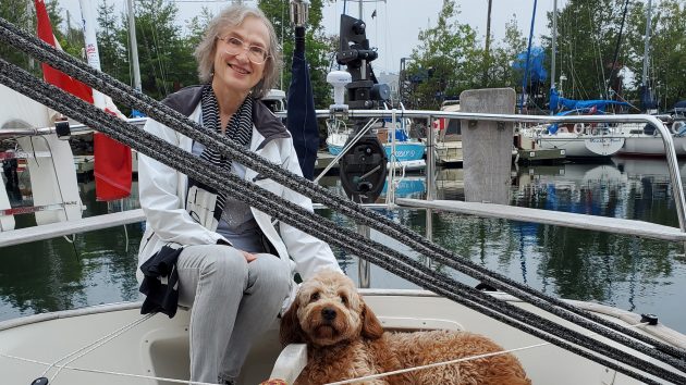 Edward Walentynowicz wife Magda and their wheat coloured dog Amber sitting on the deck of a boat