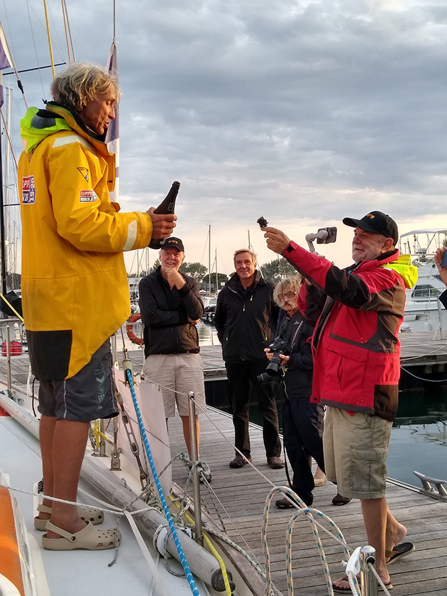 Fellow 2022 Golden Globe Race skippers, Mark Sinclair and Simon Curwen, who was the first of the entrants to cross the line, met Guy Waites when he arrived back in Les Sables d'Olonne. Credit: Julie Waites