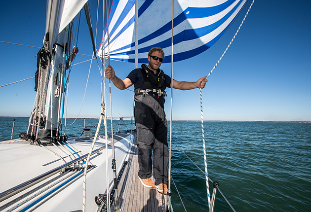 A man wearing a lifejacket holding on to two lines