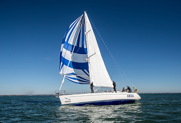A yacht with a blue and white sail
