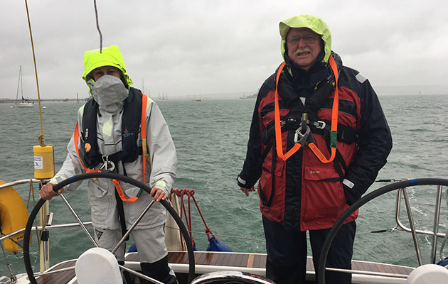 Crew on a yacht wearing waerproofs during a squall