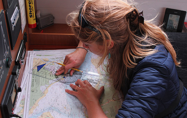 A woman plotting a course on a chart during a Day Skipper course