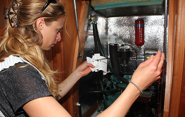 A woman checking an engine on a yacht