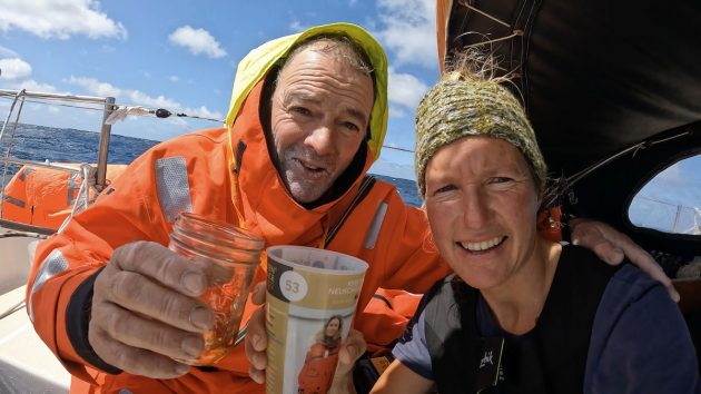 Kirsten Neuschafer and Tapio Lehtinen share rum after rescuing the Finnish skipper from his liferaft. Credit: Kirsten Nesuchafer/GGR 2022