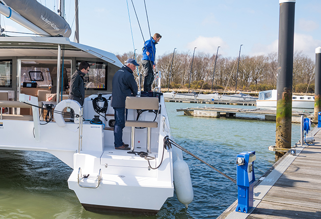 Catamaran mooring skills for a yacht charter holiday: Once you have attached a stern line you can use the engines to bring the boat alongside