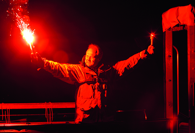 A man holding a pyrotechnic flare and a Electronic Visual Distress Signals (EVDS).