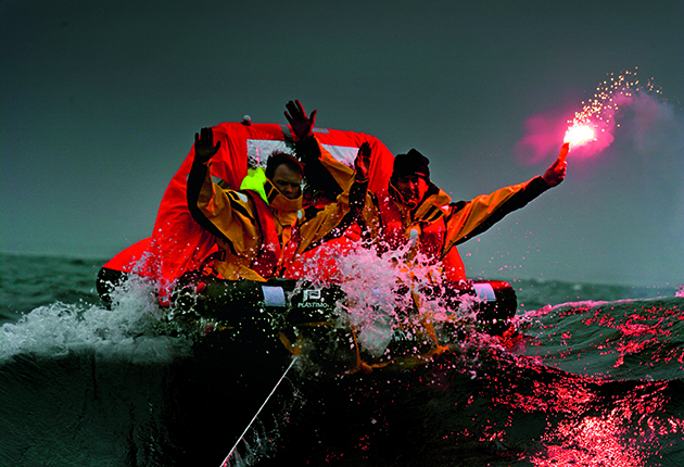 Men in a liferaft, with a lit flare