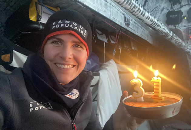 Cremer holding a 31st birthday cake while taking part in the Vendee Globe