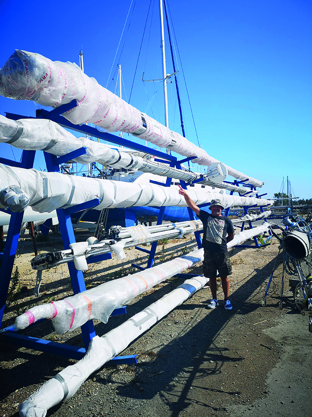 a man standing next to yacht masts from boats which are being used for canal cruising in france