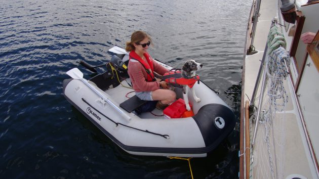 A woman coming alongside a boat in a dinghy