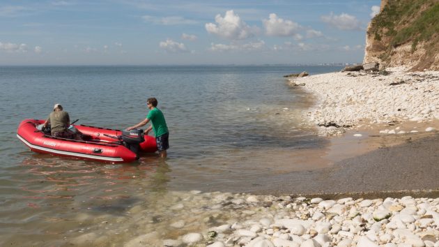 Two people getting into a red dinghy
