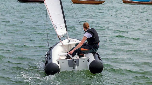 A man in a lifejacket sailing a dinghy