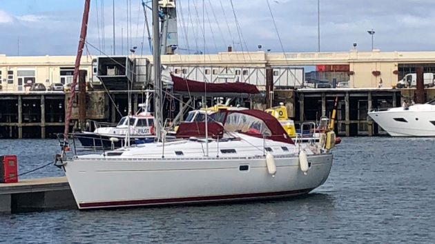 A boat with a white hull and red canopy moored against a pontoon