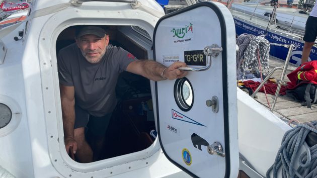 2022 Golden Globe Race skipper Michael Guggenberger looking out of his submarine door on his boat