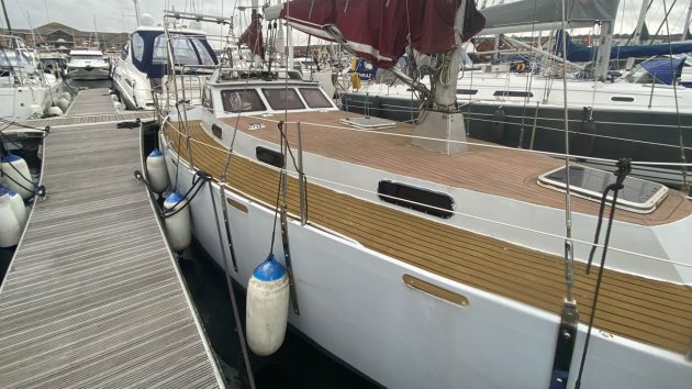 The hull of a yacht with a fake teak deck