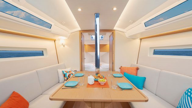 Image of below deck, with benches either side and a rectangular dining table.
