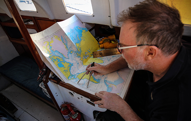 A Golden Globe Race sailor looks at a chart