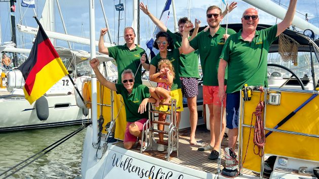 The 7 Wolkenschlösschen crew members smiling on deck, in sunny weather. They are all wearing t-shirts apart from Lonneke