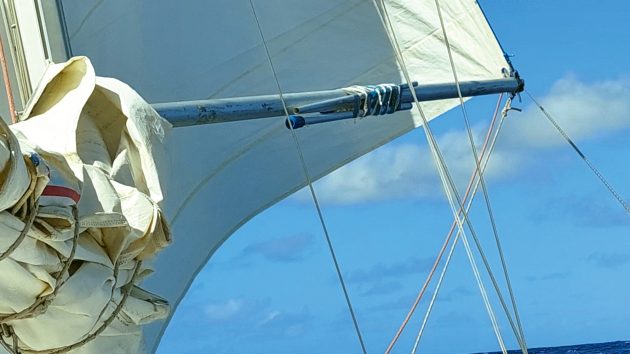 A spinnaker pole, which someone has braced and reinforced. The weather is sunny with a few clouds.
