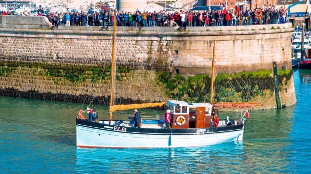 A classic yacht next to the harbour wall
