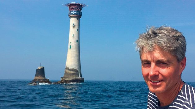 Peter with a lighthouse and the sea behind