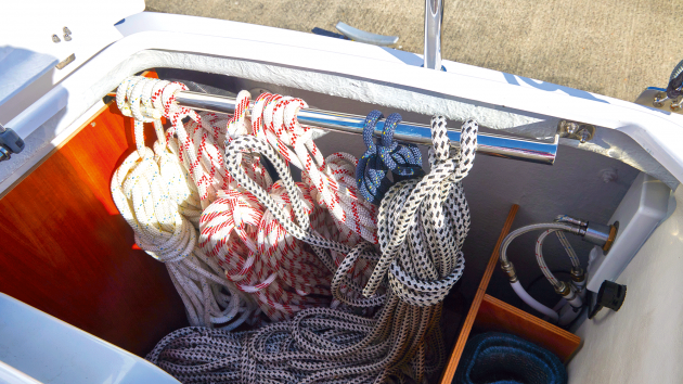 Helm-seat lockers are lined with wood, and bars keep mooring lines and sheets tidy.