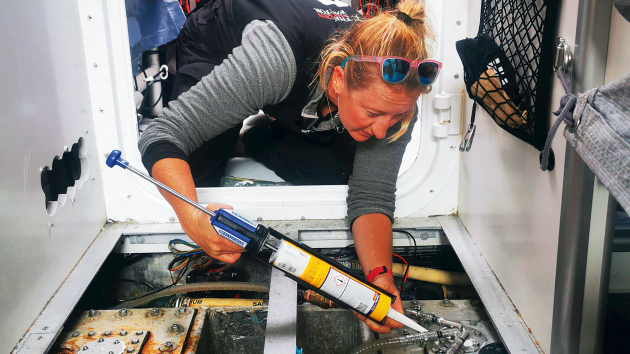 Rachel trying to slow down a leak from the seal on the water tank whilst on passage.