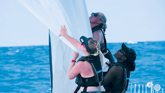 Molly, Junella and Rachel taking down a wrapped spinnaker.